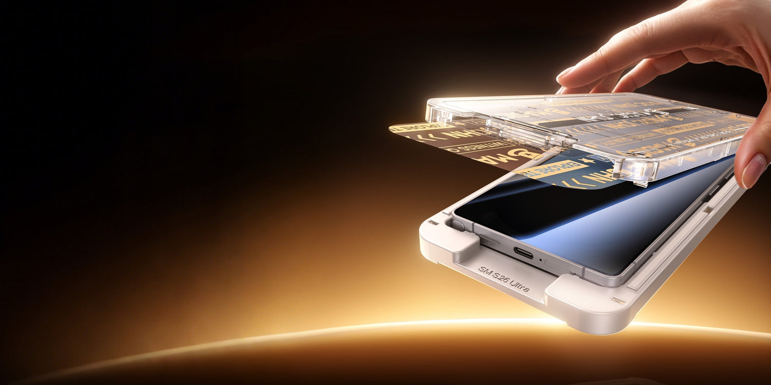 Hand applying a phone screen protector onto a smartphone.